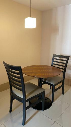 a wooden table with two chairs and a table and a light at HOSPEDE-SE JÁ CULLINAN PARTICULAR in Brasilia
