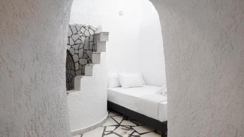a room with a white bed with a window at White Haven Cave Home in Mesaria