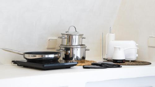 a kitchen counter with a pot and a pan on it at White Haven Cave Home in Mesaria