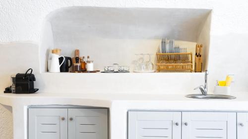 a kitchen counter with white cabinets and a sink at White Haven Cave Home in Mesaria