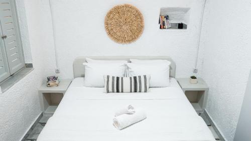 a white bed with two pillows on it in a room at White Haven Cave Home in Mesaria
