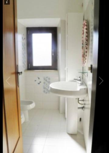 Baño blanco con lavabo y aseo en Ai piedi del castello, en Scurcola Marsicana