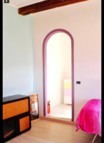 1 dormitorio con espejo y 1 cama con sábanas rosas en Ai piedi del castello, en Scurcola Marsicana