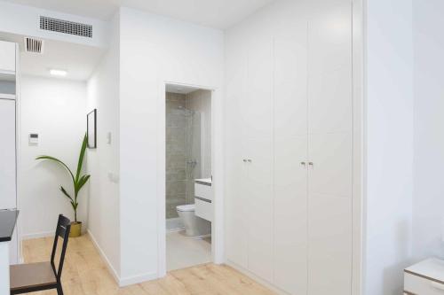 a white bathroom with a shower and a toilet at Cosmopolitan Loft y Malaga Beach in Málaga