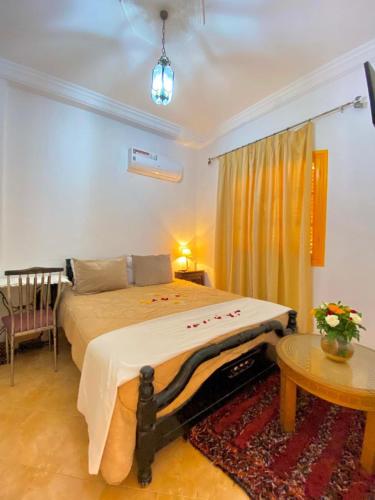 a bedroom with a bed and a table at Dar Baddi in Marrakech
