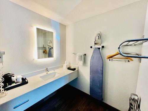La salle de bains est pourvue d'un lavabo et d'un miroir. dans l'établissement Studio 6 Suites Flagstaff AZ, à Flagstaff