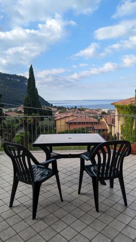 a picnic table and two chairs on a patio at Perla del Garda in Garda