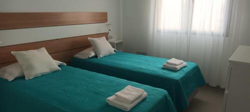 twee bedden met handdoeken bovenop in een kamer bij Apartamentos Falcón in Tinajo
