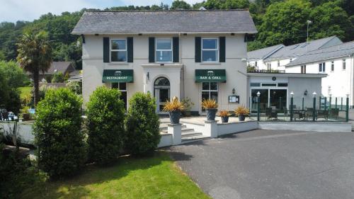 a white house with green awnings on it at Fernhill Hotel in Lyme Regis