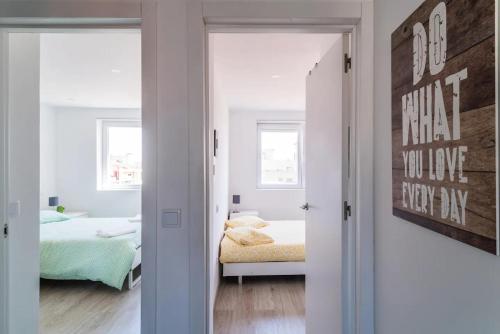 a bedroom with a bed and a room with a mirror at Encantador Apartamento à frente da praia do Sunset in Figueira da Foz