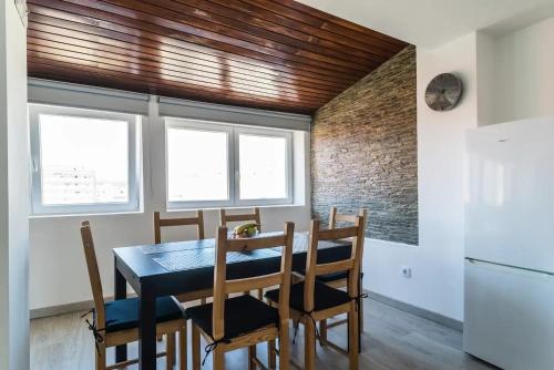 a dining room with a table and chairs and a refrigerator at Encantador Apartamento à frente da praia do Sunset in Figueira da Foz
