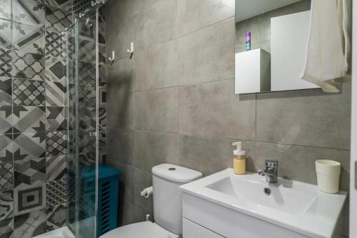 a bathroom with a toilet and a sink and a shower at Encantador Apartamento à frente da praia do Sunset in Figueira da Foz
