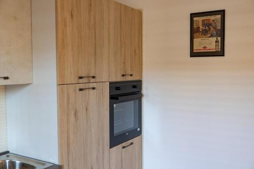 a kitchen with a wooden cabinet with an oven at Chiaro di Luna Guest House in Roccella Ionica