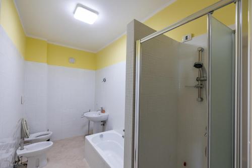 y baño con ducha, aseo y lavamanos. en Chiaro di Luna Guest House, en Roccella Ionica