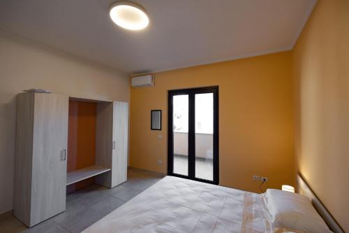 a bedroom with a large bed and a large window at Chiaro di Luna Guest House in Roccella Ionica