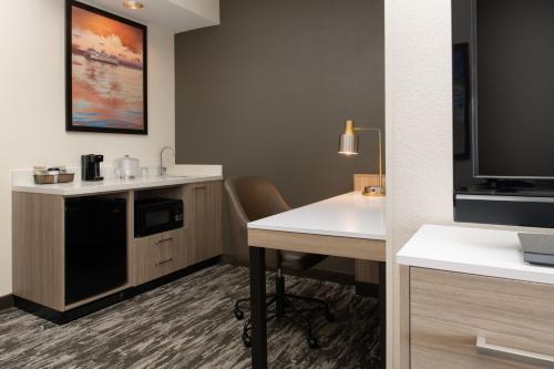 a hotel room with a desk and a tv at SpringHill Suites Seattle Downtown in Seattle