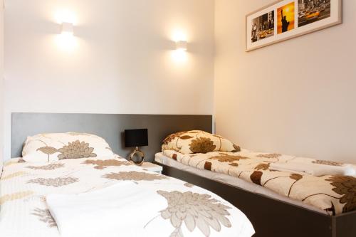 ウォムジャにあるPiękna Apartments Greyのベッド2台が隣同士に設置された部屋です。