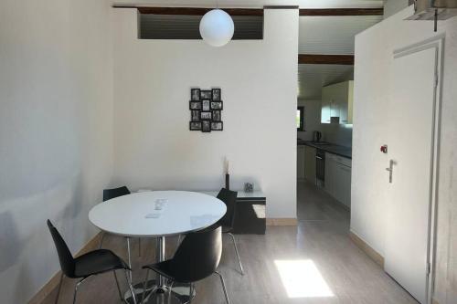 une salle à manger avec une table blanche et des chaises noires dans l'établissement Apartment in Alsace 300m from Switzland, à Pfetterhouse
