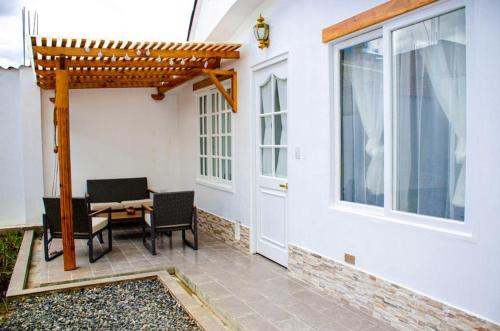 a patio with a table and chairs and a pergola at Holly House in Chachapoyas
