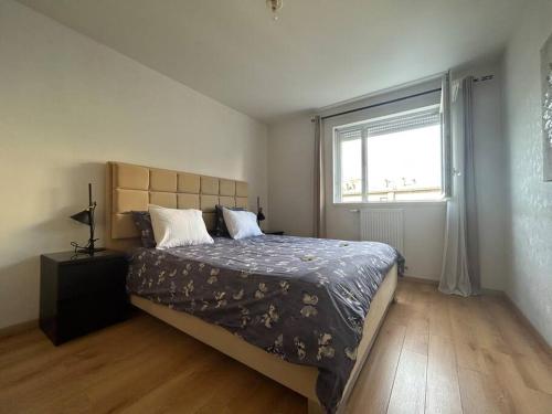 une chambre avec un grand lit et une fenêtre dans l'établissement Le Spinnaker - T3 hyper centre, à Annemasse