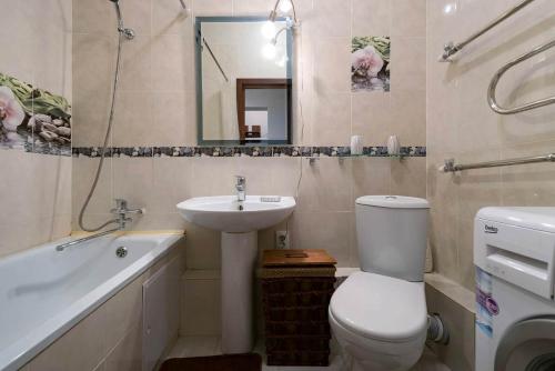 a bathroom with a toilet and a sink and a tub at Nadezhda Apartments on Kazybek bi st. in Almaty
