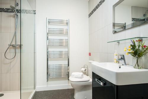 a bathroom with a toilet and a sink and a shower at Solar Sanctuary- Skyline Balcony, City Centre, Three Floors, King Beds, Netflix and more! in Bath