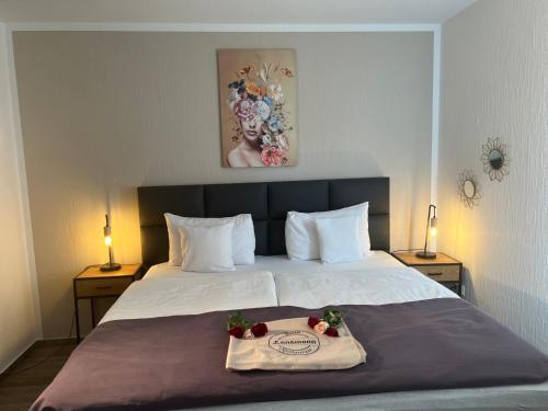 a bed with two towels and flowers on it at Hotel Restaurant Zum Landmann in Wenden