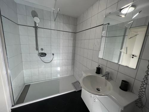 a white bathroom with a sink and a shower at Hotel Restaurant Zum Landmann in Wenden
