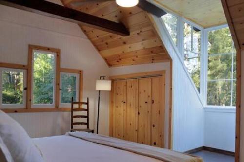 a bedroom with a bed and some windows and a ladder at Hobbit House - Charming In Town in Idyllwild