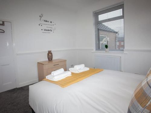 a white bedroom with a bed and a window at Bright Spacious Home with Parking - Haughton in Darlington