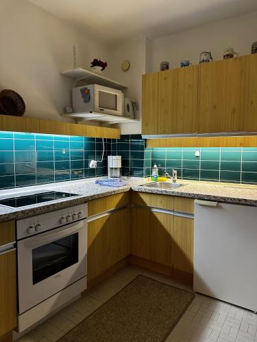 a kitchen with wooden cabinets and a stove top oven at Appartementhaus Birkenwald in Seefeld in Tirol