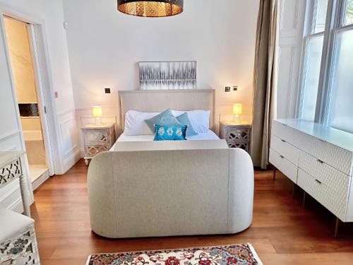 a bedroom with a large white bed and a couch at Luxurious 2-Bedroom, 2-Bathroom Paddington Retreat with En-Suite TV Bed in London
