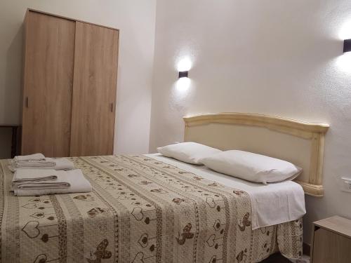 una camera da letto con letto, lenzuola e cuscini bianchi di Casa Storico Centro a Marsala