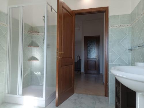 a bathroom with a shower and a sink and a mirror at Residenza Maria Antonia - Appartamento Francesco in Orosei