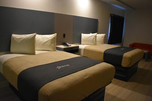 a hotel room with two beds in a room at Blue Star Inn in Houston