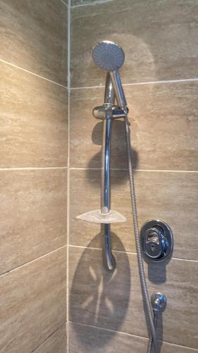 a shower with a shower head and a shower at Chessington Home Stay , 3 Bed 6 Guests Free Parking Near M25 JCT9, Chessington world of Adv Resort, Kingston, Epsom, Great for Families & Groups in Chessington