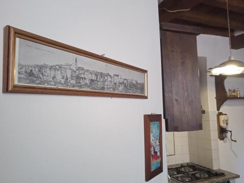a picture hanging on a wall in a kitchen at La casa di Daisy in Pitigliano