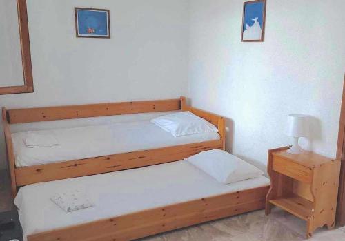 two twin beds in a room with a night stand at Cozy & Comfort in Polykhrono