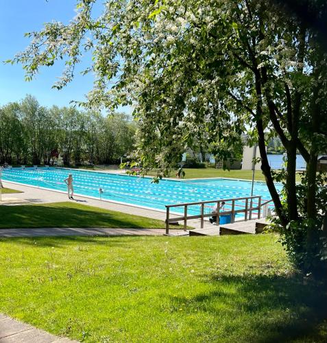 a large swimming pool with people in a park at Historic apartment near the city by the water in Solna