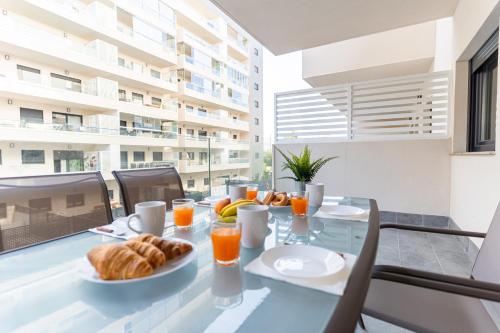 ein Esszimmer mit einem Glastisch mit Essen drauf in der Unterkunft Trendy Homes Vega de Acá in Almería