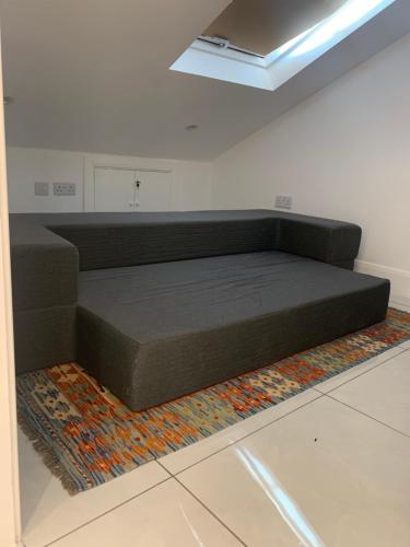 a bed sitting on a rug in a room at Air Conditioned Modern Double Bed Room with Private Attached Bathroom - FREE Parking - Near London Heathrow Airport & Southall Broadway in Southall