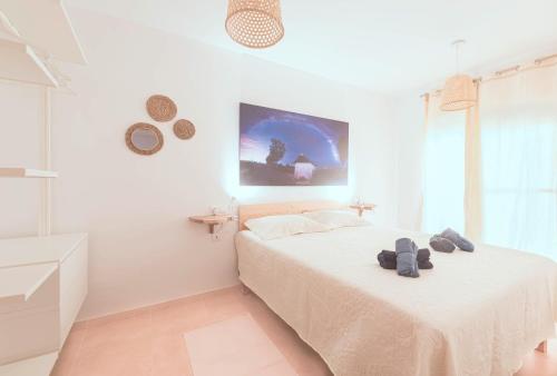 Un dormitorio blanco con una cama con dos ositos de peluche. en El Rincón de Elena Delta del Ebro, en Els Muntells