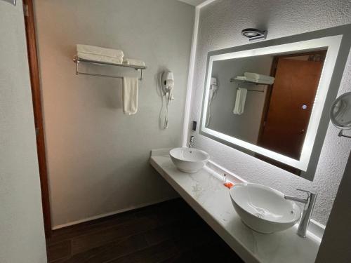 La salle de bains est pourvue de 2 lavabos et d'un grand miroir. dans l'établissement Hotel Casa María Tamasopo, à Tamasopo