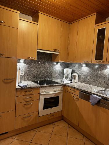 a kitchen with wooden cabinets and a stove top oven at Appartementhaus Birkenwald in Seefeld in Tirol