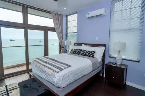 a bedroom with a bed with a view of the ocean at Holiday Apartment Dominica in Glanvillia