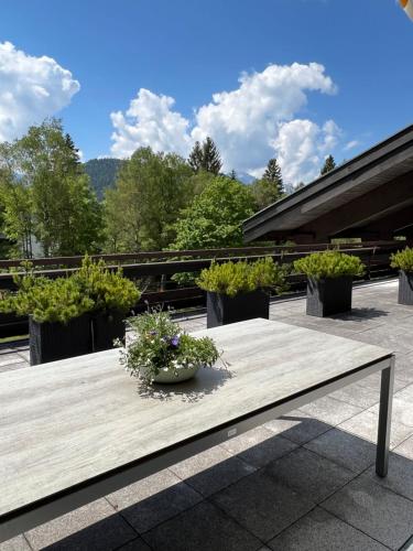 a wooden table with flowers on top of a patio at Appartementhaus Birkenwald in Seefeld in Tirol
