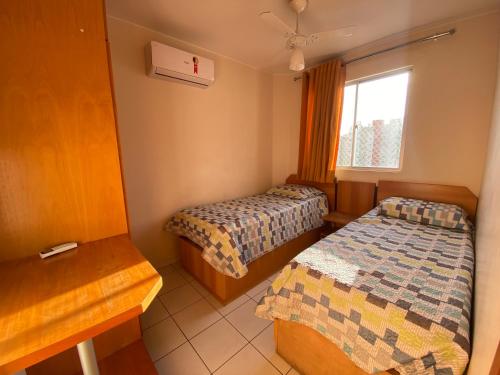 a room with two beds and a window at Apto 2 Quartos Caldas Novas Millennium com Wi-Fi in Caldas Novas