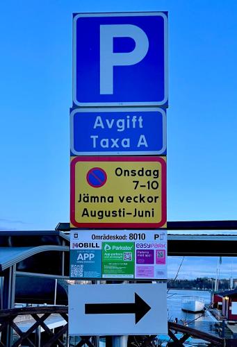 a parking sign with an arrow pointing to a parking lot at Historic apartment near the city by the water in Solna