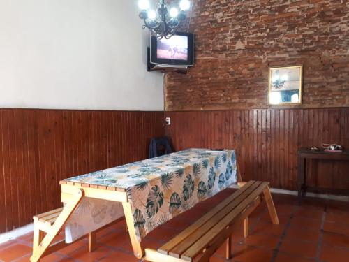 a wooden bench sitting in a room with a tv at Alojamiento hostel Lodeolga "La Florida" in Rosario