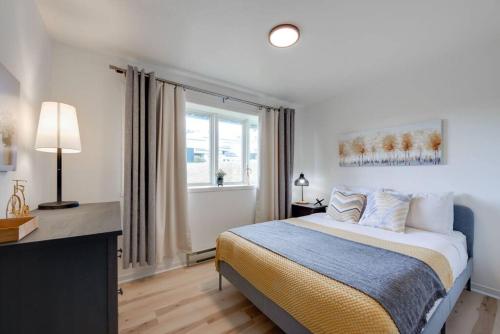 een witte slaapkamer met een bed en een raam bij The Érablière, 3 bedrooms, 7 people in Saint-Férréol-les-Neiges